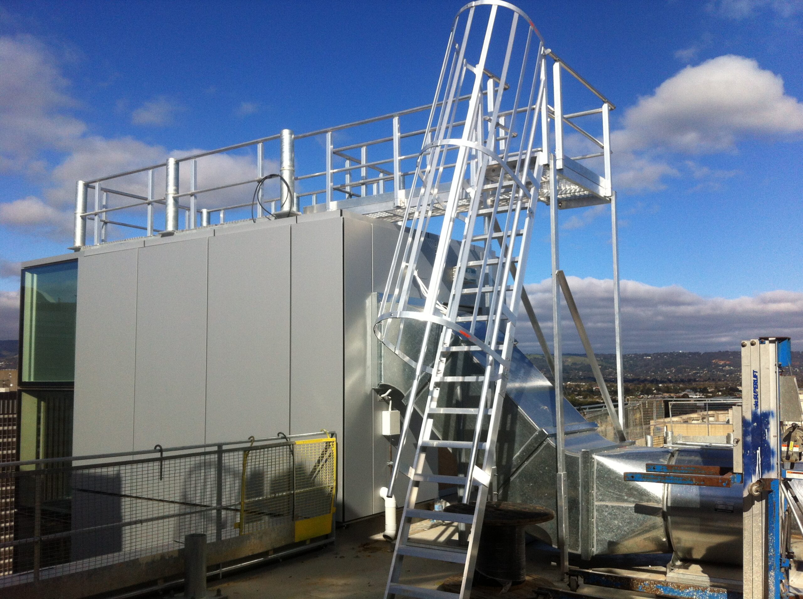 Safe access ladder and platform system for working at heights on a commercial building.