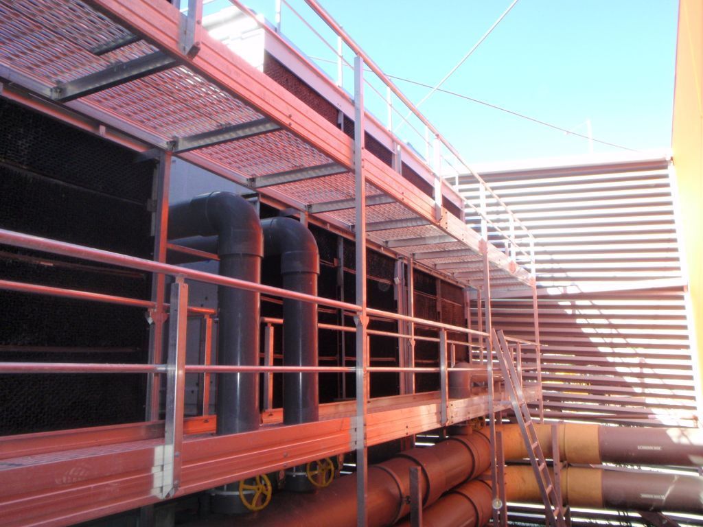 Aluminium walkway system with safety railings and pipes, designed for safe access to cooling towers and roof maintenance, reflecting RISSafety's commitment to height safety solutions.