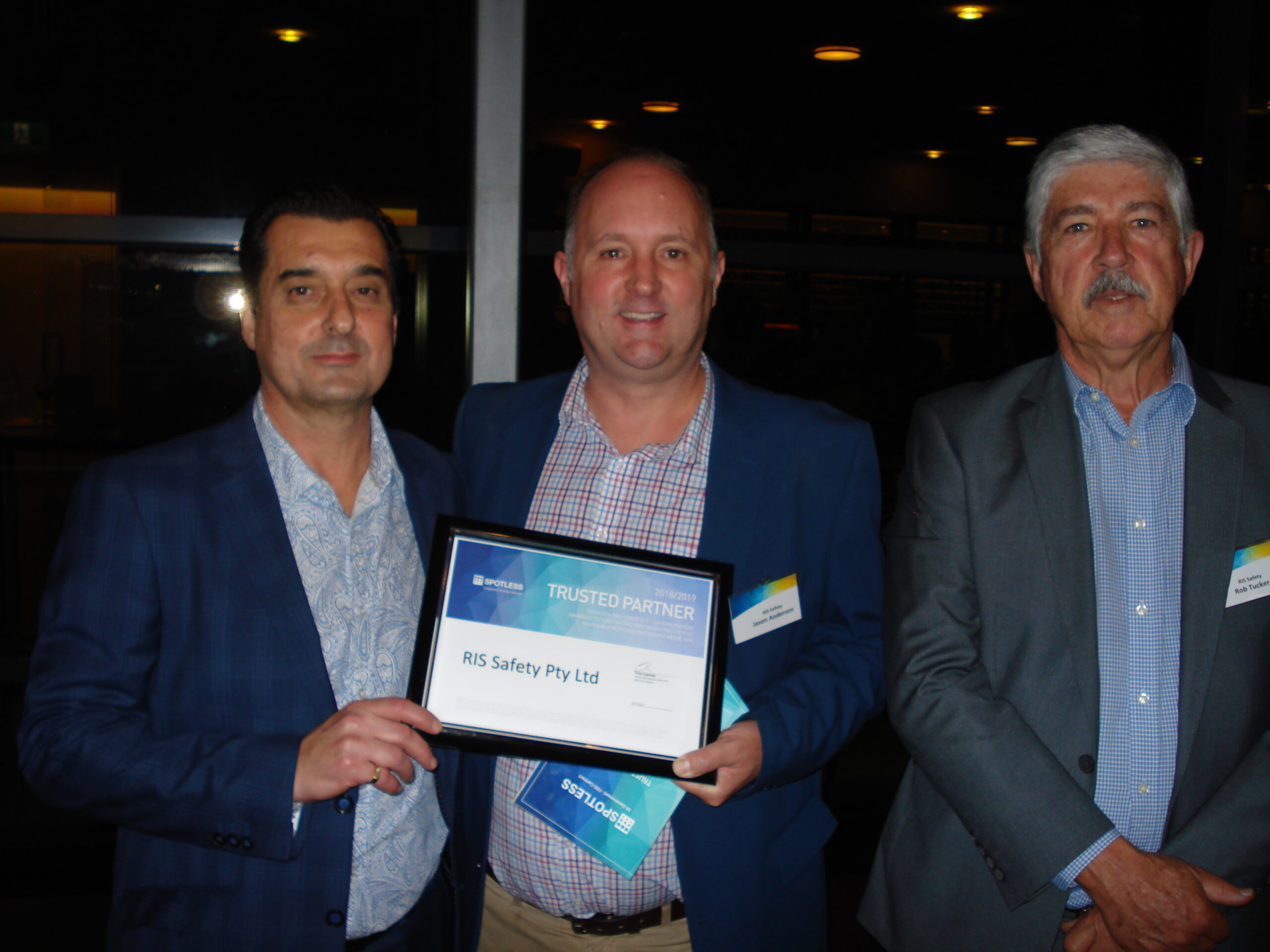 RISSafety team members holding Spotless Trusted Partner award certificate.
