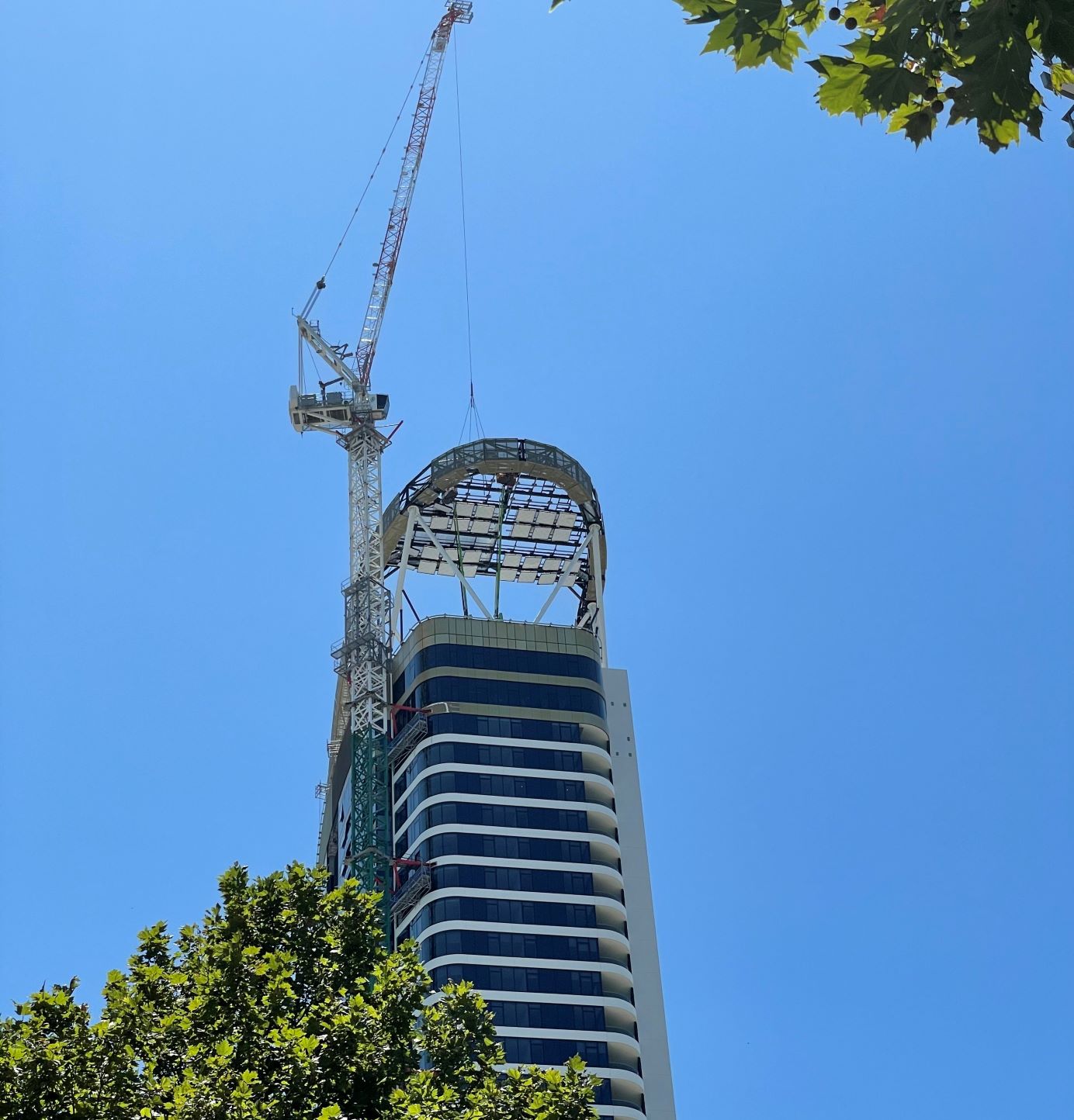 Construction crane and heliostat atop a 39-storey building at Rhodes Central precinct.