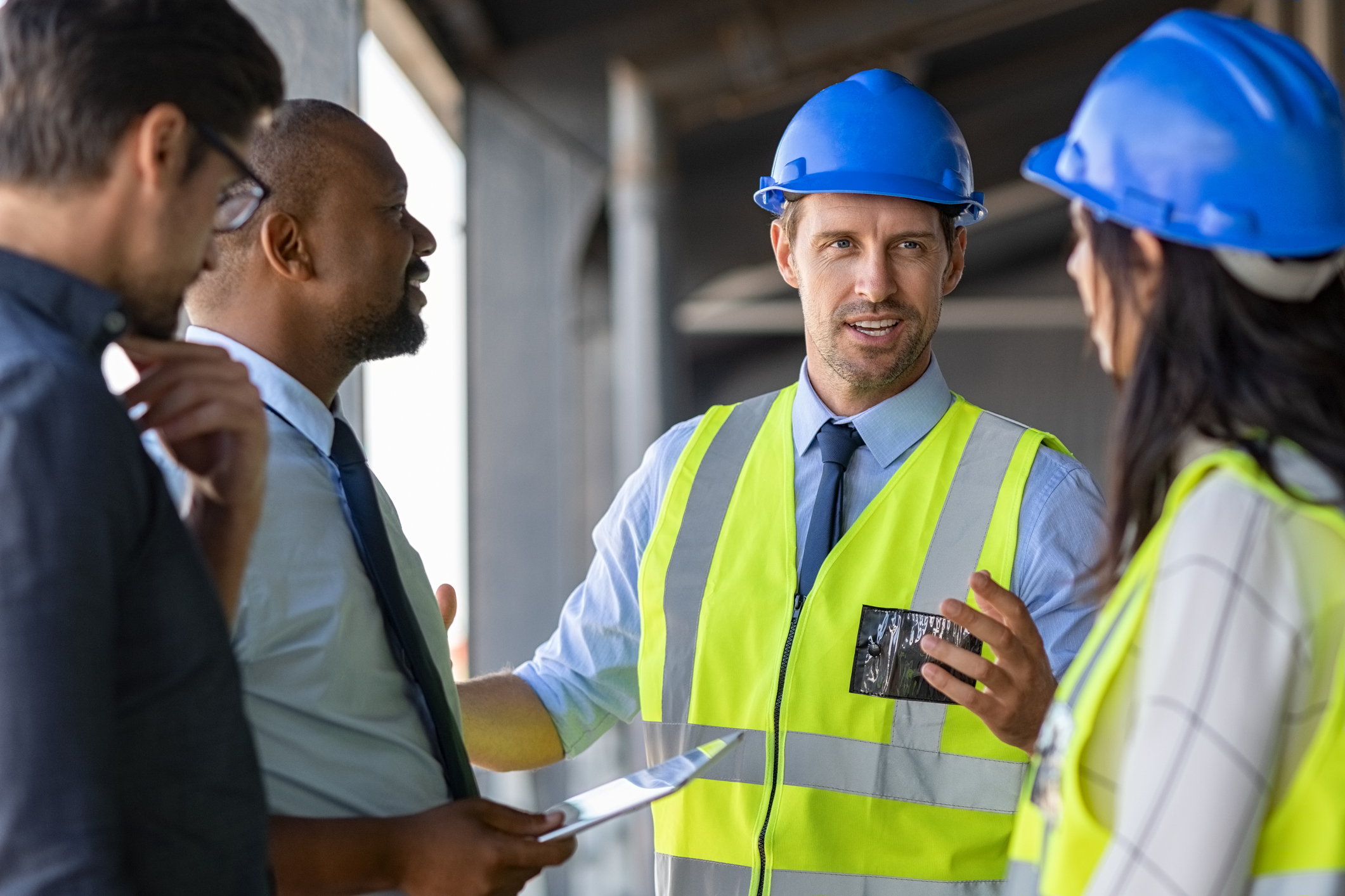 Building manager discussing height safety obligations with construction workers and colleagues.