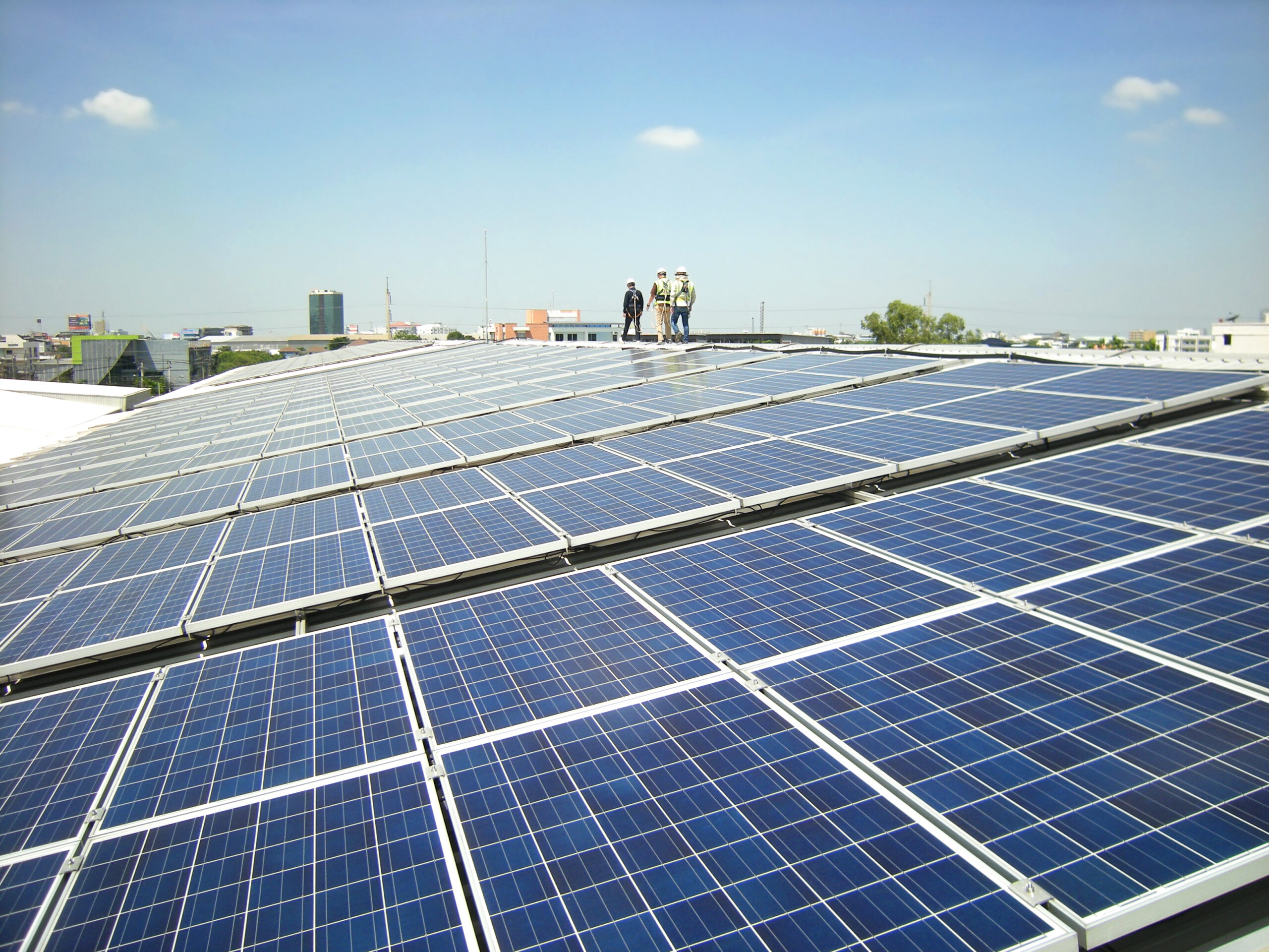 Solar panels on a rooftop and maintenance workers inspecting the system