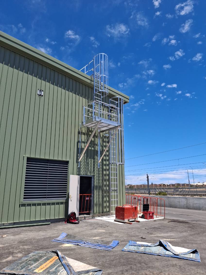 Certified anchor point system on industrial building for height safety compliance.