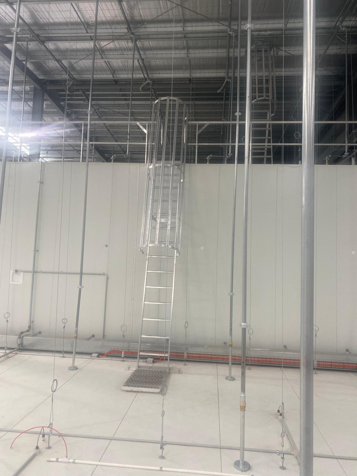 Height safety access ladder and scaffolding in a large warehouse environment.